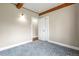 Bedroom with wood-beamed ceiling, carpeting, access doors, and a closet at 3995 Easley Rd, Golden, CO 80403