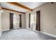 Carpeted bedroom featuring a wood-beamed ceiling, two windows with curtains, and neutral paint at 3995 Easley Rd, Golden, CO 80403