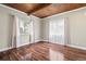 Bedroom with wood-beamed ceilings, wood flooring, and dual windows allowing for natural light at 3995 Easley Rd, Golden, CO 80403