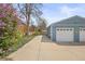 Long driveway leading to a spacious two-car garage, surrounded by lush landscaping at 3995 Easley Rd, Golden, CO 80403