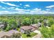 Aerial view of a suburban home with a well-manicured lawn and mature trees, set against a mountain backdrop at 6716 W Rowland Ave, Littleton, CO 80128