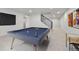 Basement recreation room with a pool table and staircase leading up to the main level of the home at 6716 W Rowland Ave, Littleton, CO 80128