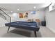 Basement recreation room featuring a pool table and comfortable seating near a staircase leading to the upper level at 6716 W Rowland Ave, Littleton, CO 80128