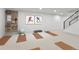 Bright basement activity area with yoga mats, work out equipment, pegboard tool organizer, and a staircase at 6716 W Rowland Ave, Littleton, CO 80128