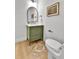 Bathroom featuring a modern vanity, toilet, and an arched mirror at 6716 W Rowland Ave, Littleton, CO 80128