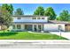 Charming two-story home with a green lawn and easy access from the sidewalk at 6716 W Rowland Ave, Littleton, CO 80128