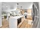 Spacious kitchen with a large island and stainless-steel appliances and open to living room at 6716 W Rowland Ave, Littleton, CO 80128
