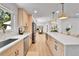 Open-concept kitchen featuring an island, stainless steel appliances, and hardwood flooring at 6716 W Rowland Ave, Littleton, CO 80128