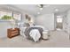 Bright main bedroom with a neutral color palette and carpet flooring, shutters and ensuite bathroom at 6716 W Rowland Ave, Littleton, CO 80128