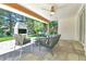 Covered patio featuring stone floors, comfortable seating, and a built-in brick barbecue grill with a lovely yard view at 6716 W Rowland Ave, Littleton, CO 80128
