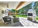 Covered patio with comfortable seating, a built-in brick fireplace, and a view of the landscaped backyard at 6716 W Rowland Ave, Littleton, CO 80128