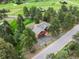 Beautiful aerial view of the house surrounded by mature trees, green space, and a pond at 28465 Cragmont Dr, Evergreen, CO 80439