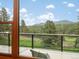 Scenic view from balcony overlooking lush landscape and distant mountains on a bright, sunny day at 28465 Cragmont Dr, Evergreen, CO 80439