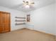 Bright bedroom featuring a window, wood floors, door, and custom shelves at 28465 Cragmont Dr, Evergreen, CO 80439