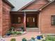 Charming front porch with brick pathway and flower pots leads to a wooden door at 28465 Cragmont Dr, Evergreen, CO 80439