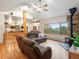 Open living room with wood floors, stone fireplace, and an adjacent kitchen and dining area at 28465 Cragmont Dr, Evergreen, CO 80439