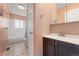 Bathroom featuring tile flooring, shower-tub combo, and modern vanity with ample lighting at 980 S Nile Way, Aurora, CO 80012