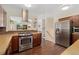 Modern kitchen featuring stainless steel appliances, wood cabinets, and dark wood flooring at 980 S Nile Way, Aurora, CO 80012