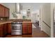Well-equipped kitchen with stainless steel appliances, hardwood floors, and a modern range hood at 980 S Nile Way, Aurora, CO 80012