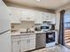 Cozy kitchen with white cabinets, stainless steel appliances, and adjacent sliding door to outdoor space at 17681 E Loyola Dr # E, Aurora, CO 80013