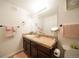 Bathroom featuring a granite countertop, large mirror, vanity lighting, and neutral decor at 5732 S Addison Way # E, Aurora, CO 80016