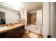 This bathroom features a tub, a shower with tile surround, granite countertops, and tile flooring at 5732 S Addison Way # E, Aurora, CO 80016