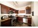 Compact kitchen featuring stainless steel appliances and dark wood cabinetry at 5732 S Addison Way # E, Aurora, CO 80016