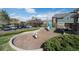 Community playground features a slide, spring rider, and seating, set in a mulched area with surrounding greenery at 5732 S Addison Way # E, Aurora, CO 80016