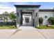Elegant home featuring a gray stone portico, black metal gate, and manicured landscaping at 96 Glenmoor Ln, Cherry Hills Village, CO 80113