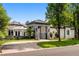 Stunning home exterior featuring manicured landscaping, a stylish gated entry, and a circular driveway at 96 Glenmoor Ln, Cherry Hills Village, CO 80113