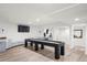 Basement game room with shuffleboard table, TV, and ample space for entertainment and leisure at 96 Glenmoor Ln, Cherry Hills Village, CO 80113