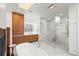 Spa bathroom with wood cabinetry, skylight, soaking tub, and glass shower at 96 Glenmoor Ln, Cherry Hills Village, CO 80113