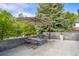 Stone patio area with built in seating, a fire pit, umbrella and mature trees at 96 Glenmoor Ln, Cherry Hills Village, CO 80113