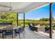 Covered patio with a dining table, fire pit, and view of lush greenery for outdoor entertaining at 96 Glenmoor Ln, Cherry Hills Village, CO 80113