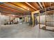 Unfinished basement with exposed wood beams, concrete foundation, and ample storage space at 1758 S Tucson St, Aurora, CO 80012
