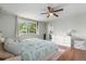 Light-filled bedroom with large window, ceiling fan, and ensuite bathroom access at 1758 S Tucson St, Aurora, CO 80012