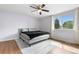 Well-lit bedroom with wood floors, ceiling fan, and a view of the outdoors at 1758 S Tucson St, Aurora, CO 80012