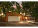 Two-story brick home featuring an attached two-car garage and covered front porch under a colorful evening sky at 1758 S Tucson St, Aurora, CO 80012