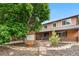 Well-maintained home with brick accents, mature trees, and a landscaped front yard at 1758 S Tucson St, Aurora, CO 80012