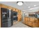 Spacious kitchen with a black refrigerator, stainless steel ovens, wooden cabinets, and eat-in kitchen area at 1758 S Tucson St, Aurora, CO 80012