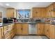 Traditional kitchen featuring wooden cabinetry, stainless steel appliances, and granite countertops under a window at 1758 S Tucson St, Aurora, CO 80012