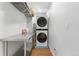 Modern laundry room with stacked washer and dryer, metal folding table and wooden floors at 1758 S Tucson St, Aurora, CO 80012