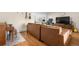 Open living room with a leather sofa, piano, and TV with workspace in the background at 1758 S Tucson St, Aurora, CO 80012