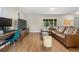 Living room featuring a work desk, leather couch and ottoman, hardwood flooring and window with outdoor view at 1758 S Tucson St, Aurora, CO 80012