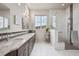 Bright bathroom featuring double sinks, a shower with tile surround, and great natural light at 5810 Moss Ct, Golden, CO 80403