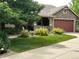 Landscaped front yard featuring a lush lawn, mature trees, and flowering bushes enhance the home's curb appeal at 5810 Moss Ct, Golden, CO 80403