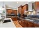 Gourmet kitchen with dark wood cabinets, stainless steel appliances, and a tile backsplash at 5810 Moss Ct, Golden, CO 80403