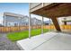 View of a backyard with wood fence, green lawn, patio, and stairs under the deck at 9283 Sedalia St, Commerce City, CO 80022