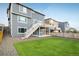 Large backyard with green lawn, wood fence, exterior stairs, and a patio at 9283 Sedalia St, Commerce City, CO 80022