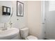 Well-lit powder room featuring a stylish vanity, round mirror and neutral walls at 9283 Sedalia St, Commerce City, CO 80022